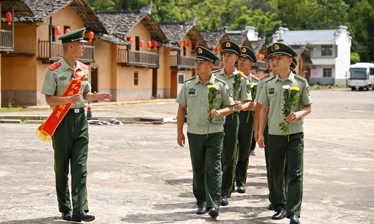 Cui Liguang, a post-90s soldier with the Ruijin squadron, explains the story of the 17 pine trees to officers and soldiers in Huawu village on July 6, 2026. Photo: Courtesy of Xu Wei