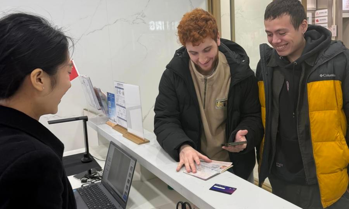 A tourist (C) from Spain applies for a tax refund at a centralized departure tax refund service center in Yuzhong District of Chongqing, southwest China, Jan. 7, 2026. (Photo by Yao Hui/Xinhua)