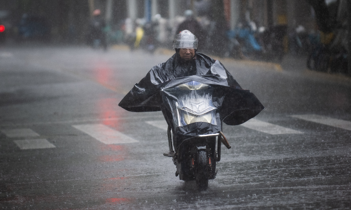 A cyclist rides through heavy rain in Shanghai on August 9, 2026. Photo: VCG