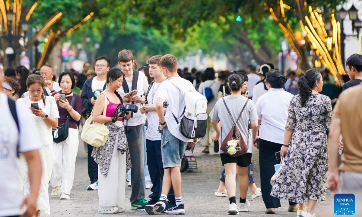 Foreign tourists visit the Central Street in Harbin, northeast China's Heilongjiang Province, July 22, 2026. Thanks to the visa-free entry policies, China has witnessed an increasing number of foreign tourists visiting China this summer. According to the official data, 77.7 percent of foreign visitors entering China in the first half of the year enjoyed visa-free entry policies. (Xinhua/Na Yuqi)