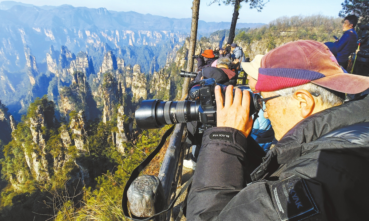 A South Korean senior citizen (right), joining a photography group, tours and takes photos at Zhangjiajie National Forest Park in Central China's Hunan Province, on January 5, 2025. Photo: VCG