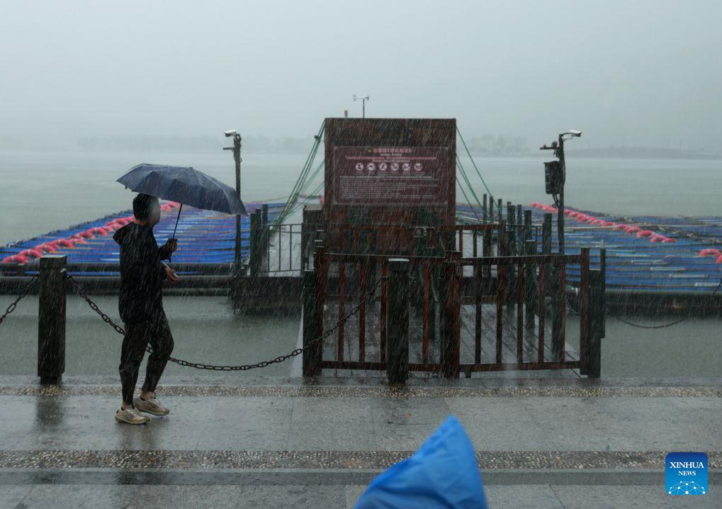 A visitor walks past a dock that is temporarily closed on the West Lake in Hangzhou, east China's Zhejiang Province, Aug. 9, 2026. China's national observatory on Sunday activated a red alert -- the highest level in the country's typhoon warning system -- as Typhoon Dolphin approaches.Typhoon Dolphin is forecast to make landfall along the country's east coast from Zhoushan in Zhejiang Province to Fuding in Fujian Province, according to the National Meteorological Center (NMC). (Xinhua/Han Chuanhao)