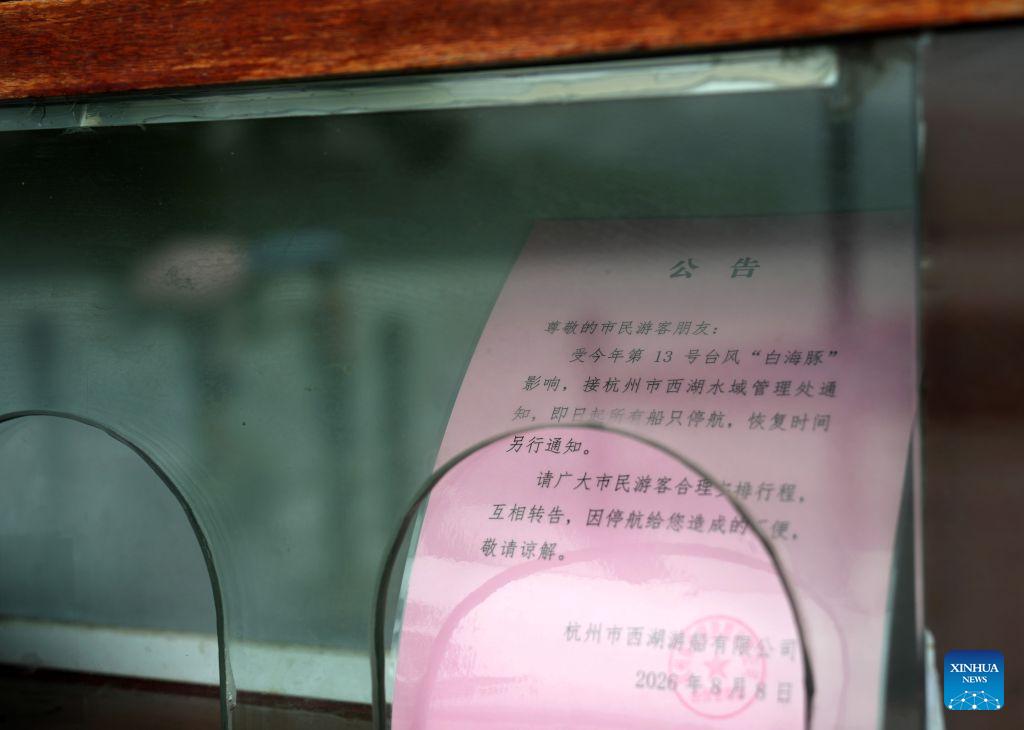 A notice on the suspension of sightseeing boats is seen at the West Lake scenic spot in Hangzhou, east China's Zhejiang Province, Aug. 9, 2026. China's national observatory on Sunday activated a red alert -- the highest level in the country's typhoon warning system -- as Typhoon Dolphin approaches.Typhoon Dolphin is forecast to make landfall along the country's east coast from Zhoushan in Zhejiang Province to Fuding in Fujian Province, according to the National Meteorological Center (NMC). (Xinhua/Han Chuanhao)