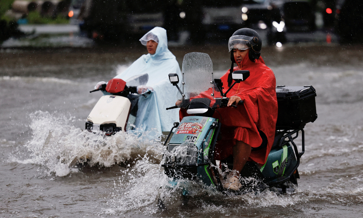 Residents ride electric bicycles through floodwaters caused by heavy rain from Typhoon Dolphin’s remnants in Zhengzhou, Central China’s Henan Province, on August 12, 2026. Photo: IC