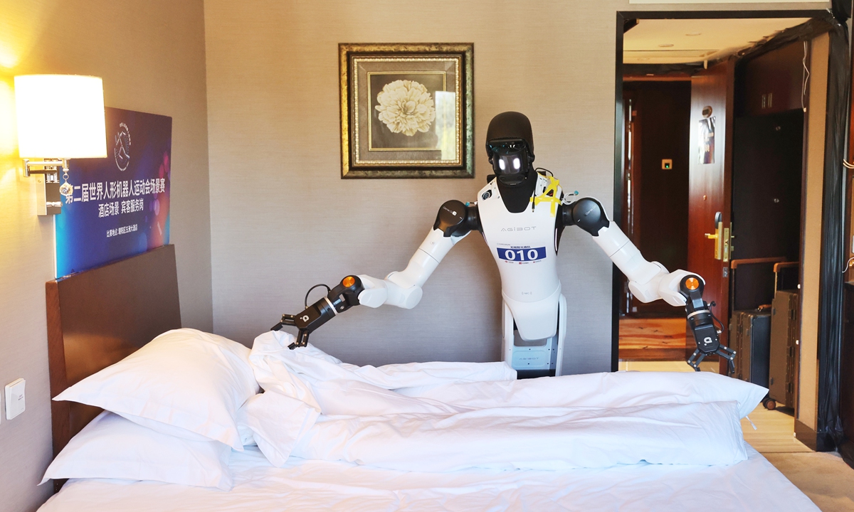 A robot makes a bed during the scenario competition of the second World Humanoid Robot Games in Beijing on August 16, 2026. Photo: VCG 