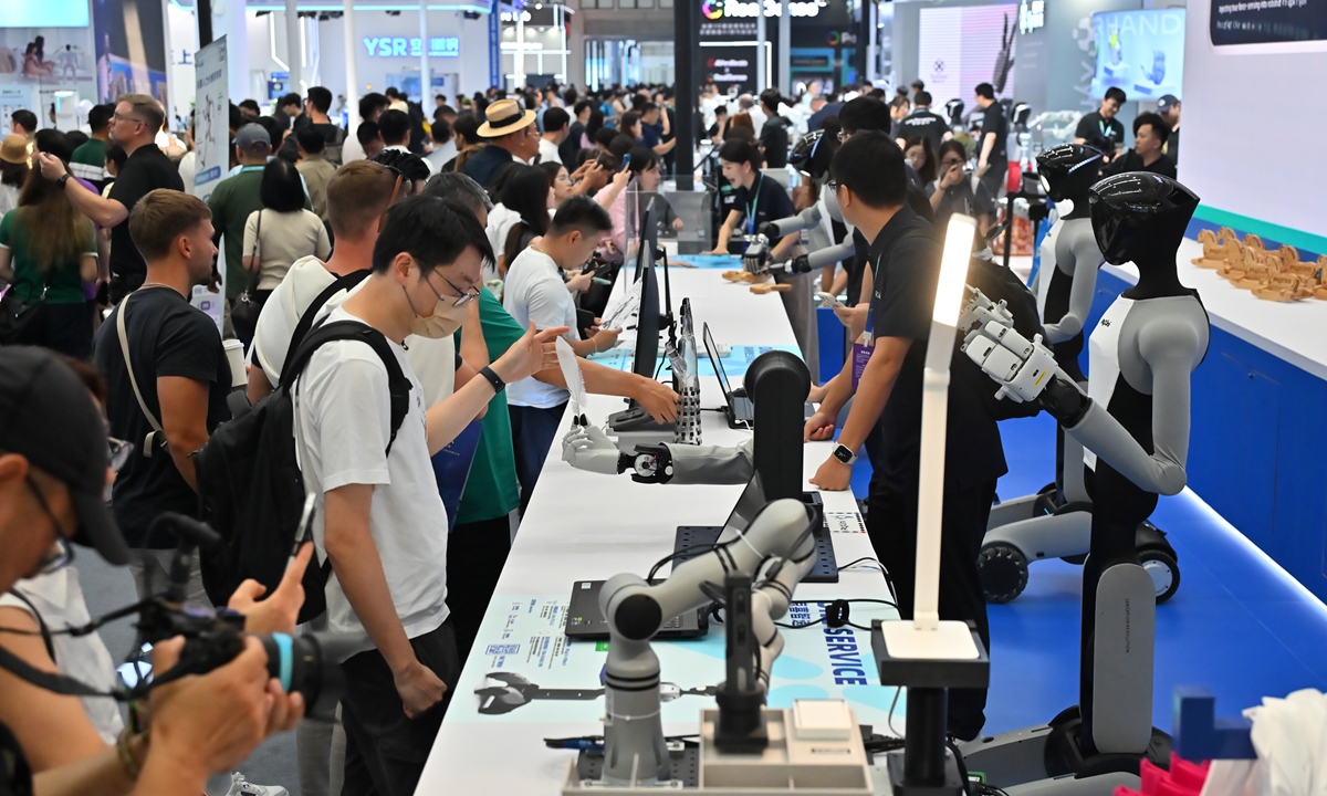 Audiences interact with robot products at the 11th World Robot Conference in Beijing on August 19, 2026. Photo: Tao Mingyang/GT