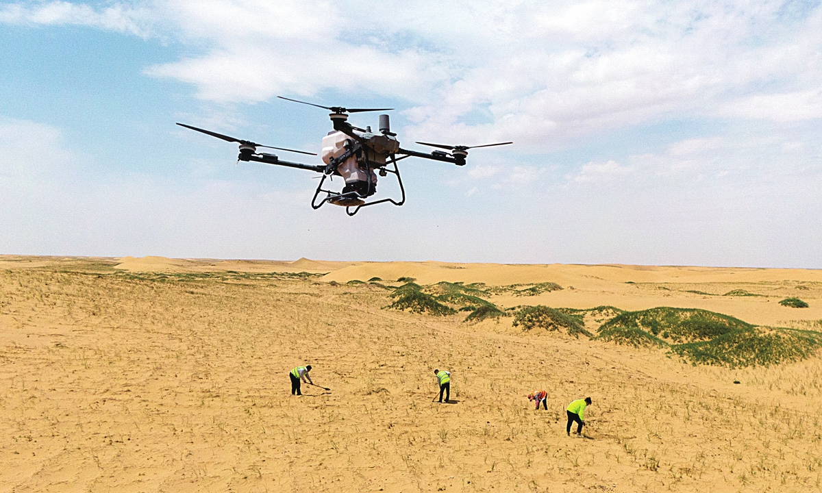 Engineering personnel operate drones to conduct aerial seeding as part of afforestation efforts in the Badain Jaran Desert in North China on June 17, 2025. Photo: VCG