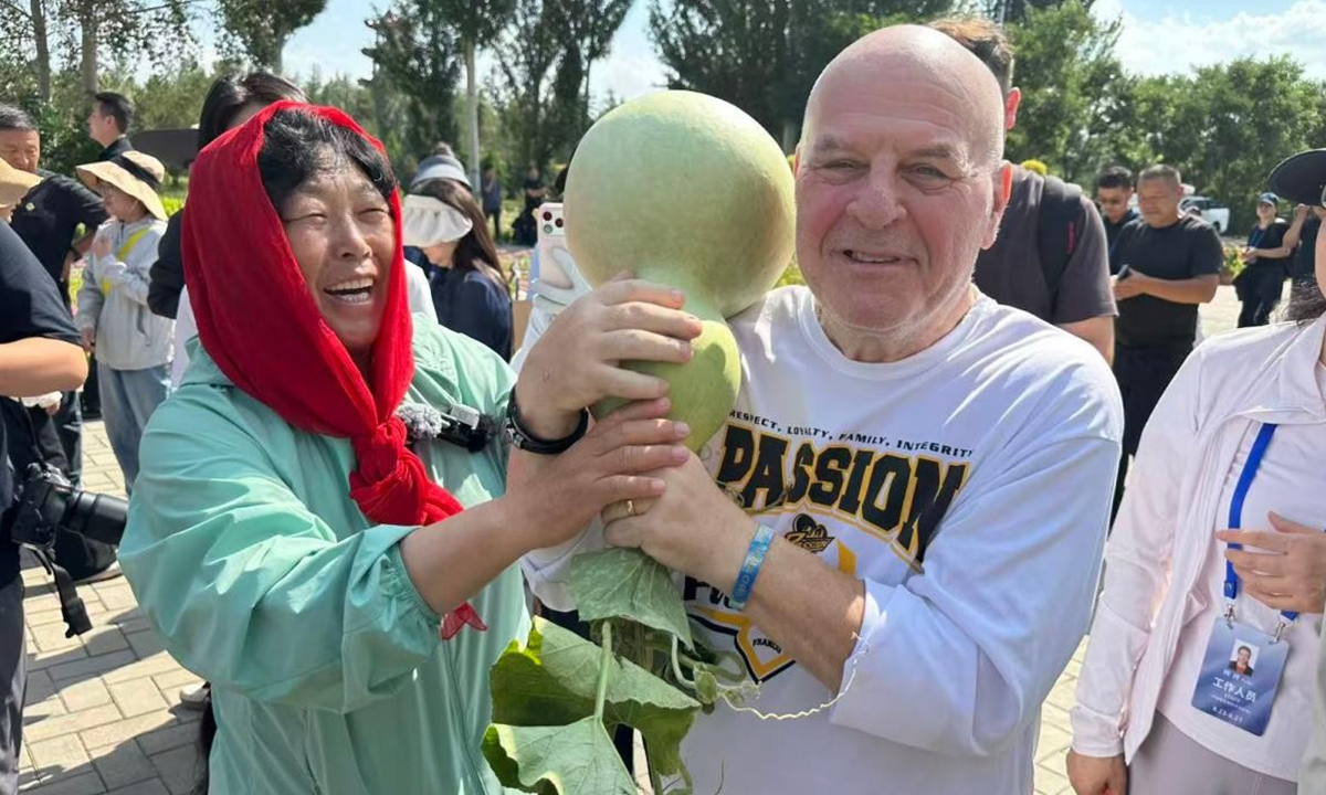 Yin Yunzhen introduces to Sakolsky the harvest from the once-barren wasteland on August 24, 2026. Photo: Lin Xiaoyi/GT