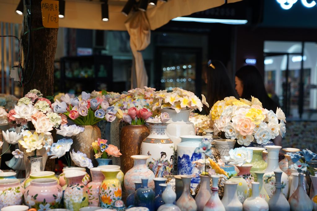 Tourists select ceramic products in Jingdezhen, east China's Jiangxi Province, July 16, 2026. (Xinhua/Zhou Mi)