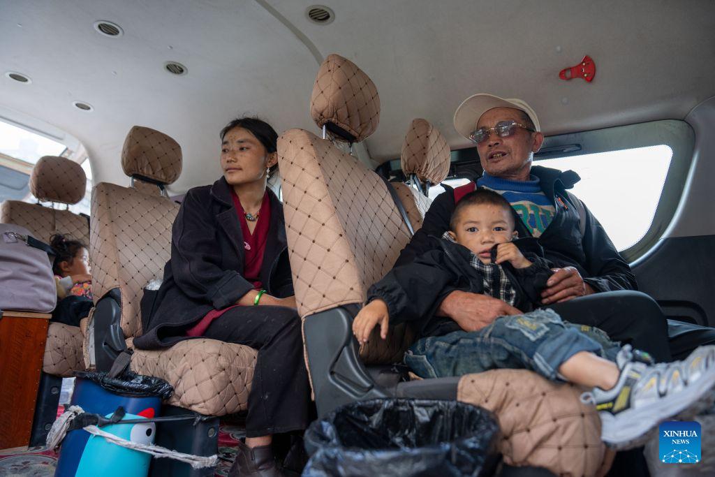 People take a vehicle and return home from a temporary relocation site in Gyirong Town, southwest China's Xizang Autonomous Region, Sept. 7, 2026. A fast-moving chain mudslide, triggered by a high-altitude glacier collapse in Nepal, struck Gyirong Port on the China-Nepal border in southwest China's Xizang Autonomous Region on Aug. 26, causing heavy casualties and leaving many missing. A barrier lake caused by the mudslide posed a serious threat to the lives and safety of the residents in the surrounding villages.A total of 499 villagers were evacuated to Gyirong Town by the local authorities for their safety and experts were organized to carry out hidden danger investigations and hydrological monitoring to assess the risks of secondary disasters.By far, the barrier lake on the upper reaches of the core affected zone of the mudslide-hit Gyirong Port has been drained. The local government has dispatched vehicles to transfer the affected people home in succession. On Monday, residents at the temporary relocation sites of Gyirong Town started returning home in an orderly manner. (Xinhua/Tenzing Nima Qadhup)