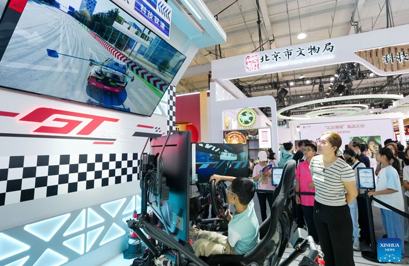 A kid experiences simulated racing driving at the themed exhibition area for culture and tourism services during the 2026 China International Fair for Trade in Services (CIFTIS) at Shougang Park in Beijing, capital of China, Sept. 12, 2026. The 2026 CIFTIS, running from Sept. 9 to 13 at Shougang Park in Beijing, has brought together 413 exhibitors at the themed exhibition area for culture and tourism services, showcasing emerging models of cultural and tourism integration. (Xinhua/Ju Huanzong)