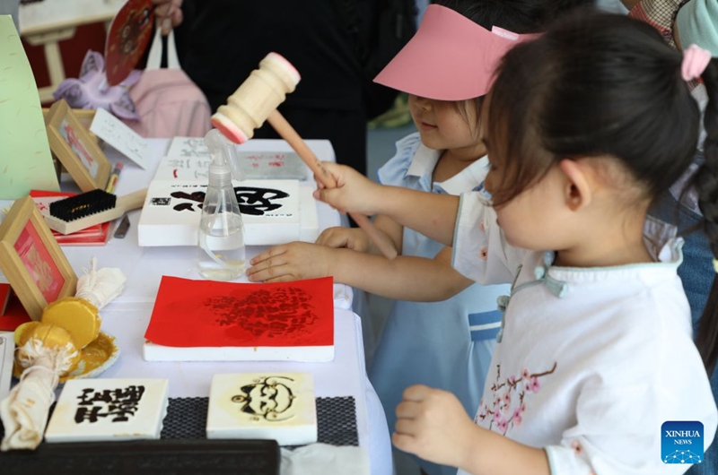 Children experience traditional rubbing craft at the themed exhibition area for culture and tourism services during the 2026 China International Fair for Trade in Services (CIFTIS) at Shougang Park in Beijing, capital of China, Sept. 12, 2026. The 2026 CIFTIS, running from Sept. 9 to 13 at Shougang Park in Beijing, has brought together 413 exhibitors at the themed exhibition area for culture and tourism services, showcasing emerging models of cultural and tourism integration. (Photo by Liang Jiayuan/Xinhua)
