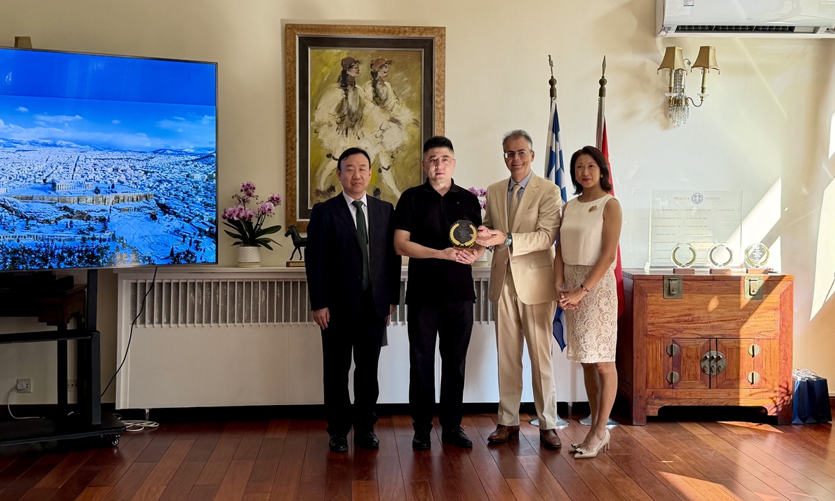 Chang Jian, Deputy Director General of the Department of European Affairs at the Chinese Ministry of Foreign Affairs (left) and Ambassador of Greece to China Evgenios Kalpyris (2nd from right) pose for a group picture with a Chinese awarded photographer in Beijing on September 23, 2026. Photos: Dong Feng/GT
