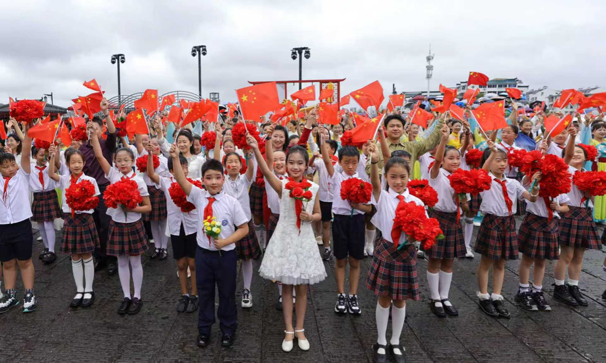 Students and performers sing patriotic songs during a National Day flash mob at Tunxi Ancient Street in Huangshan, East China’s Anhui Province, on October 1, 2026.