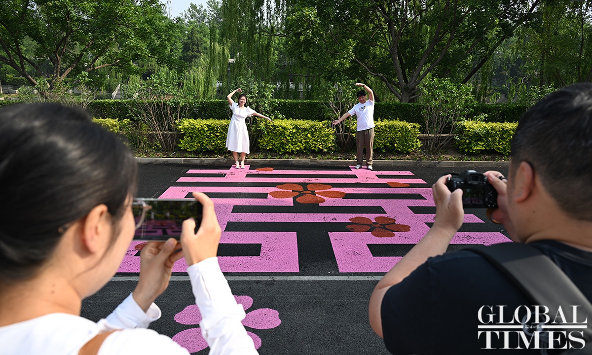 A couple poses on a vibrant pink Chinese character known as “double xi,” which signifies good luck and is often used at weddings, in front of the marriage registration office in Beijing’s Dongcheng district on May 20, 2025. In Chinese, “520” is pronounced similarly to “I love you,” making May 20 a popular date for couples to get married. Photo: Chen Tao/GT