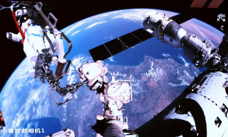 This screen image captured at Beijing Aerospace Control Center on April 16, 2026 shows Shenzhou-21 astronaut Wu Fei performing extravehicular activities outside China's orbiting space station.(Photo by Zhang Fan/Xinhua)