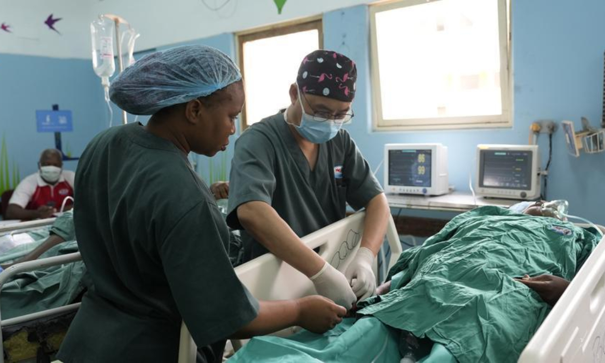 Ling Yong (R), a doctor from the Chinese medical team in Mozambique, and a local medical worker provide postoperative care to a patient, in Maputo, Mozambique, April 11, 2025.(Xinhua/Liu Jie)