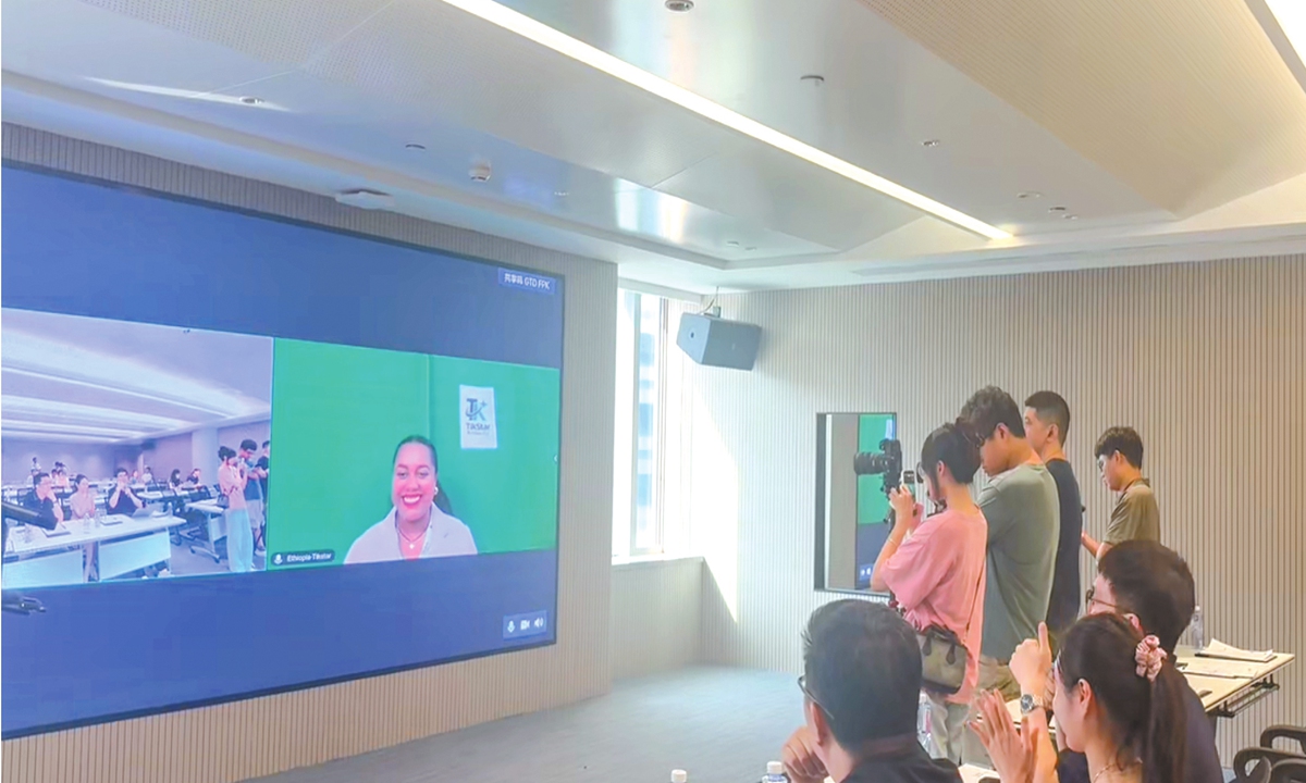 Staff members in Xiamen, East China's Fujian Province, speak with an Ethiopian client about the