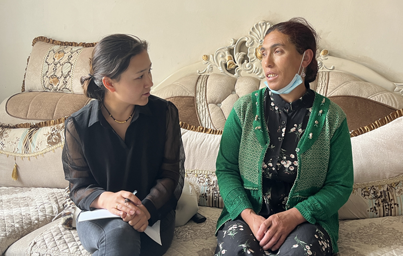 Guzailinuer Abula (left) talks with local residents. /Tianshannet