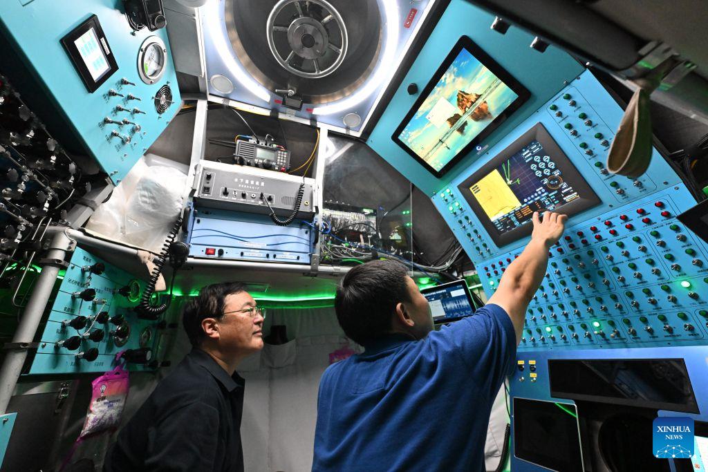 Submersible pilot Tang Jialing (R) checks the manned deep-sea submersible Jiaolong on Oct. 15, 2026. China's research vessel Deep Sea No. 1, carrying manned deep-sea submersible Jiaolong, is currently on the western Pacific Ocean for deep-sea scientific research.Jiaolong successfully completed its 470th dive on Oct. 15.A Xinhua reporter aboard Jiaolong photographed the exploration of the mysterious underwater world. (Xinhua/Li Xin)