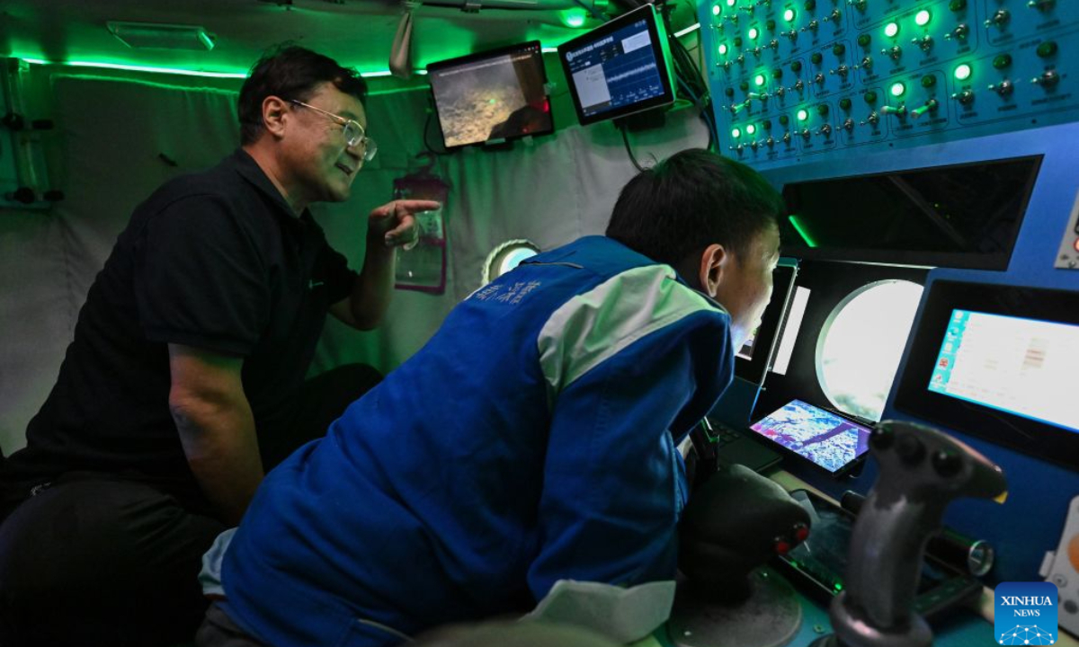 Deep sea researcher Sun Yongfu (L) and submersible pilot Tang Jialing observe from the porthole on the manned deep-sea submersible Jiaolong on Oct. 15, 2026. China's research vessel Deep Sea No. 1, carrying manned deep-sea submersible Jiaolong, is currently on the western Pacific Ocean for deep-sea scientific research.Jiaolong successfully completed its 470th dive on Oct. 15.A Xinhua reporter aboard Jiaolong photographed the exploration of the mysterious underwater world. (Xinhua/Li Xin)