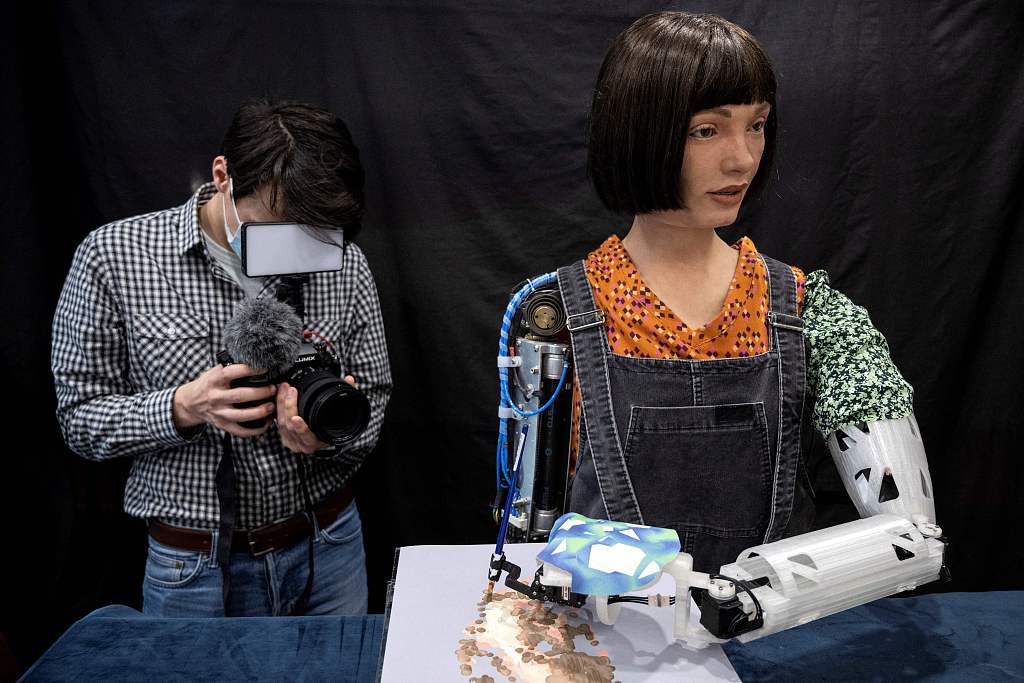 'Ai-Da,' an ultra-realistic robot, paints an image during a photocall in central London, April 4, 2022. /CFP