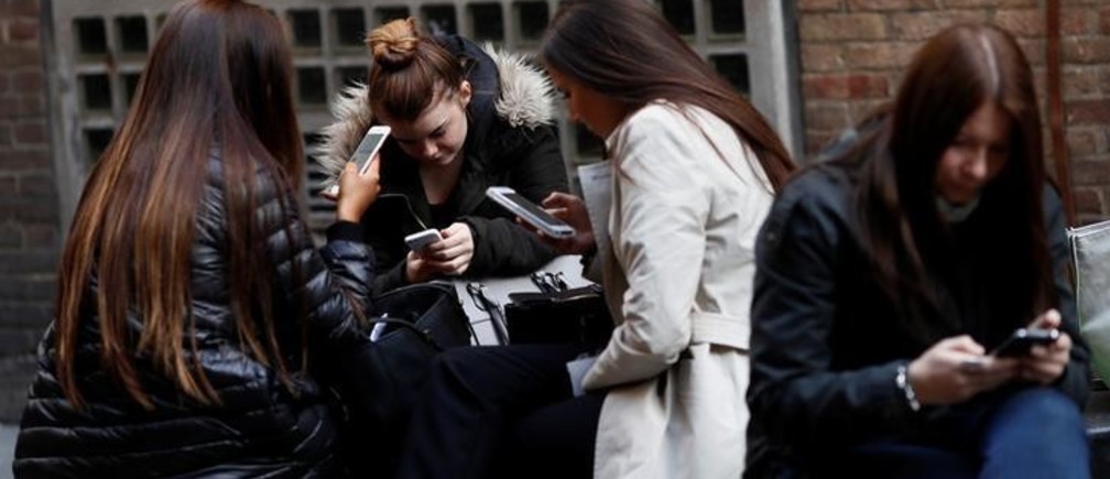 Women look at their mobile phones in London, Britain October 6, 2016. REUTERS/Stefan Wermuth  SEARCH "WERMUTH PHONES" FOR THIS STORY. SEARCH "THE WIDER IMAGE" FOR ALL STORIES.