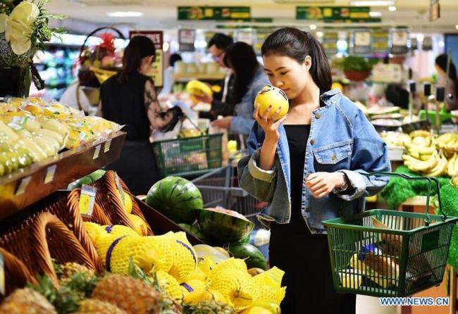 A citizen selects melon at a supermarket in Shijiazhuang, capital of north China's Hebei Province. [File photo: Xinhua]