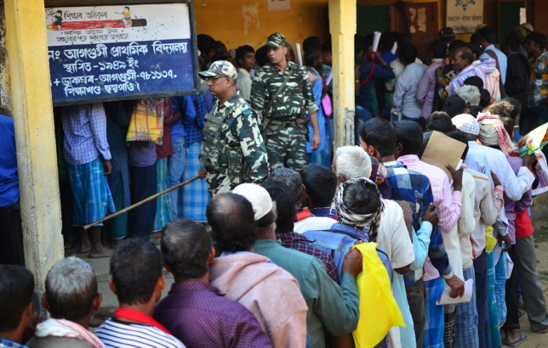 People stand in line to check their names on the first draft of the National Register of Citizens at Gumi village in Assam state