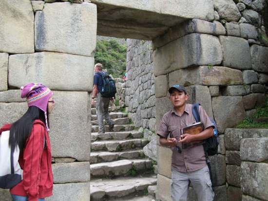 在秘鲁世界文化遗产地马丘比丘，导游（右）向来自中国的游客介绍文化背景。新华社记者郝云甫摄