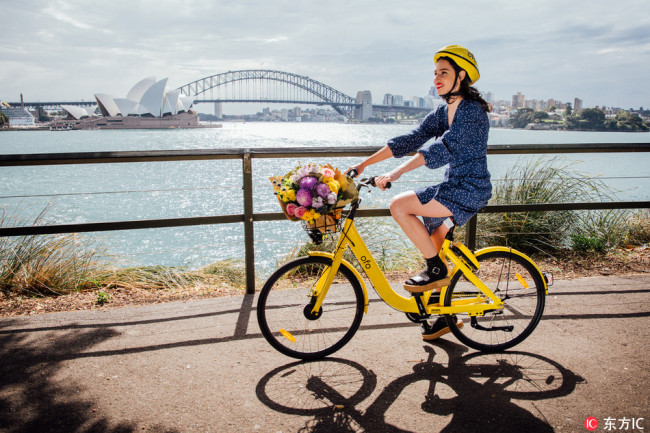A woman rides an ofo shared-bike in Sydney, Australia, on September 25, 2017. [Photo: IC]
