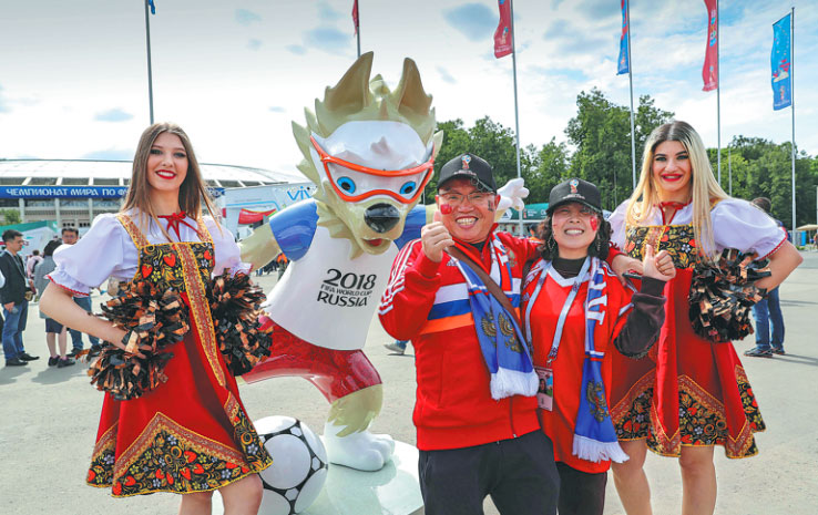 A Chinese couple from Jiangxi province say they are excited about attending World Cup matches as they pose with a mascot in Moscow on June 14, 2018. [File photo: Xinhua]