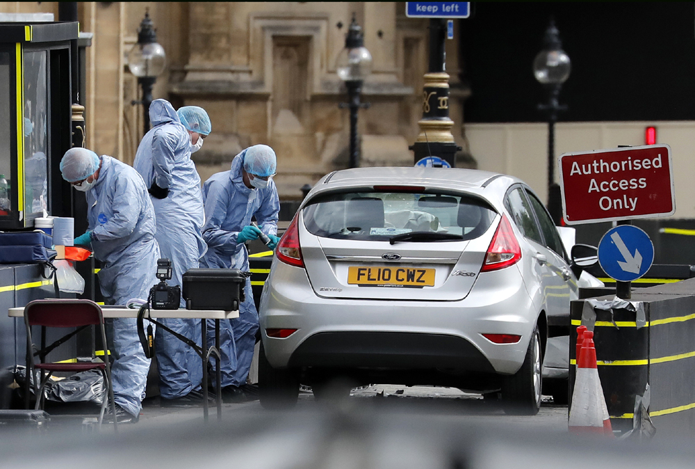 Forensics officers work near the car that crashed into security barriers outside the Houses of Parliament in London, Tuesday, Aug. 14, 2018.[Photo: AP/Frank Augstein]