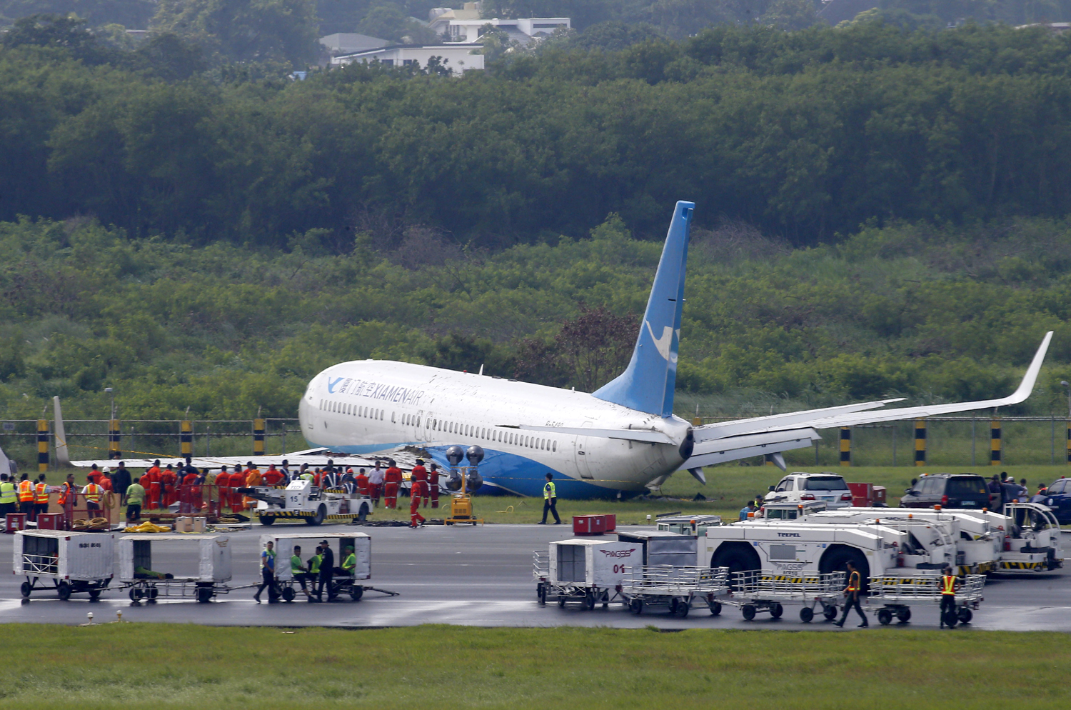 A Boeing passenger plane from China, a Xiamen Air, sits on the grassy portion of the runway of the Ninoy Aquino International Airport after it skidded off the runway while landing Friday, Aug. 17, 2018 in suburban Pasay city southeast of Manila, Philippines. All the passengers and crew of Xiamen Air Flight 8667 were safe and were taken to an airport terminal, where they were given blankets and food before being taken to a hotel. [Photo: AP/Bullit Marquez]