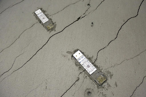 FILE - In this photo taken Monday, Oct. 3, 2016, stress gauges are placed along a wall with floor-to-ceiling cracks in the parking garage of the Millennium Tower in San Francisco. The 58-story tower has gained notoriety as the leaning tower of San Francisco. It's not just leaning. It's sinking, too. And engineers hired to assess the problem say it shows no immediate sign of stopping. The sleek, mirrored high-rise that opened in 2009 as a haven for the city's well-heeled has sunk 16 inches and is leaning at least 2 inches toward other skyscrapers in the crowded downtown financial district. [Photo: AP/Eric Risberg]