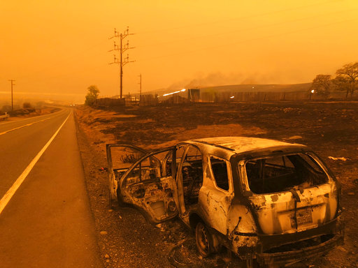 A burned out car sits on the side of the road in Paradise, Calif., Friday, Nov. 9, 2018, after a wildfire swept through the area. [Photo:AP]