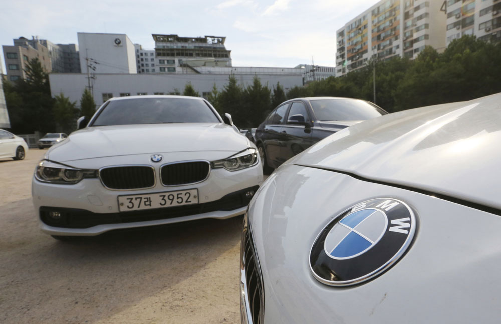 In this Aug. 14, 2018 file photo, BMW cars are parked for an emergency safety check at the playground of an elementary school near a BMW service center in Seoul, South Korea. South Korea says on Monday, Dec. 24, 2018. it will fine BMW 11.2 billion won ($9.9 million) and file a criminal complaint against the company with state prosecutors over an allegedly botched response to dozens of engine fires reported in the country. [Photo:AP]