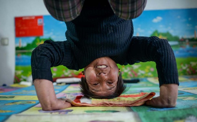 Guo's wife performs a difficult yoga position. [Photo: IC]
