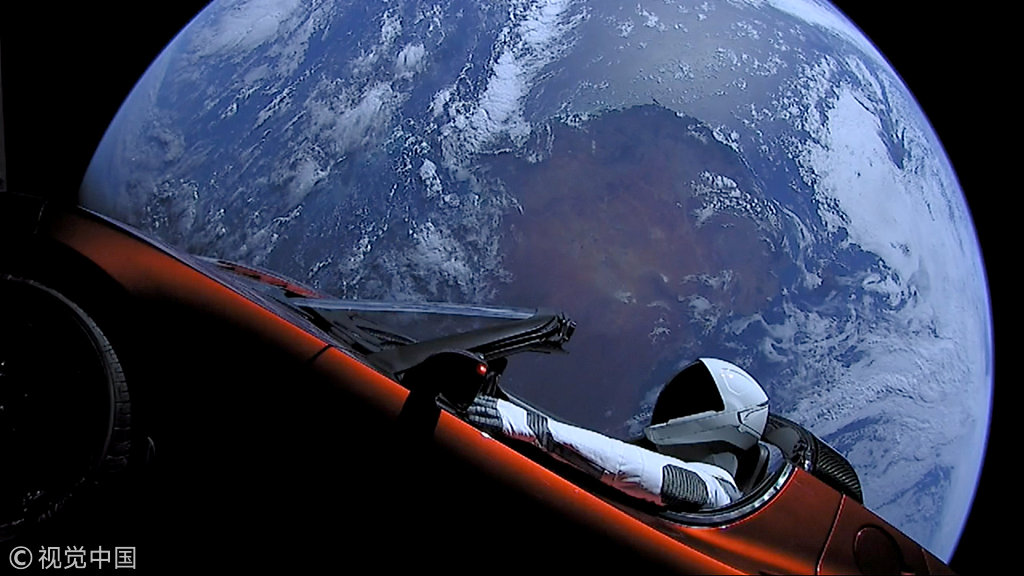 A cherry red Tesla Roadster automobile floats through space after it was carried there by SpaceX's Falcon Heavy in this image obtained by on February 9, 2018. [Photo: VCG]