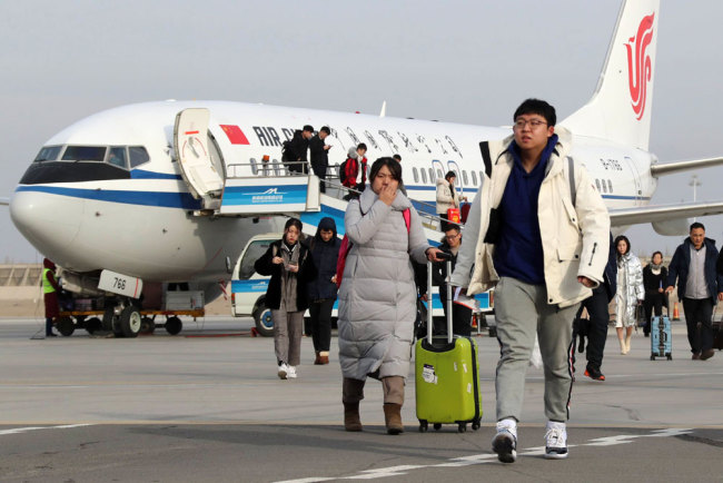 Passengers get off a plane from the Hami Airport in northwest China’s Xinjiang Uygur autonomous region, January 13, 2019. [Photo: IC]