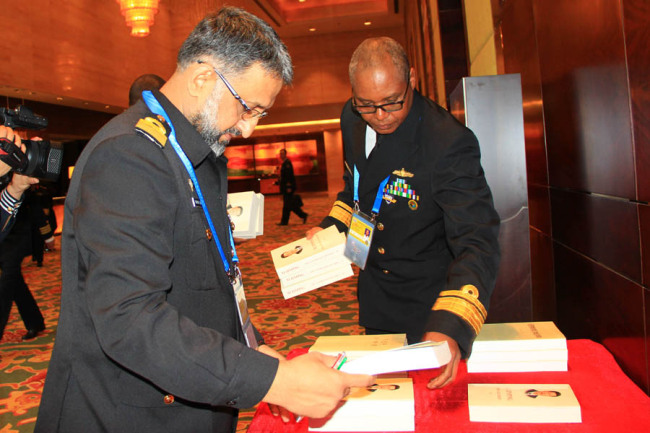 Representatives of foreign navies pick the work by Chinese President Xi Jinping at the seminar on Building a Maritime Community of Shared Future in Qingdao on Apr 24, 2019. [Photo provided to China Plus]